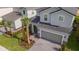 Aerial view of a well-manicured home with a gray roof and a paver driveway, surrounded by lush landscaping at 7352 Oakmoss Loop, Davenport, FL 33837