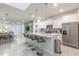 Bright, open-concept kitchen featuring a large island, stainless steel appliances, and seamless flow into the living area at 7352 Oakmoss Loop, Davenport, FL 33837