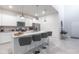 Modern kitchen with white cabinetry, stainless steel appliances, a spacious island, and a view into the entryway at 7352 Oakmoss Loop, Davenport, FL 33837