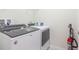 Laundry room showcasing modern washer and dryer units with storage options at 7352 Oakmoss Loop, Davenport, FL 33837