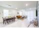 Bright and airy living area with open floor plan, tile flooring, and dining space; perfect for Gathering gatherings at 7352 Oakmoss Loop, Davenport, FL 33837