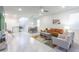 Bright open-concept living room with tile floors, modern furniture, and plenty of natural light at 7352 Oakmoss Loop, Davenport, FL 33837
