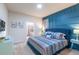 Cozy bedroom with a blue accent wall, plush bedding, and en-suite bathroom access for added convenience at 7352 Oakmoss Loop, Davenport, FL 33837