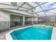Backyard screened pool with patio featuring grill and dining set at 7352 Oakmoss Loop, Davenport, FL 33837