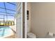 Powder room featuring a toilet and a door leading to the pool at 7577 Oak Spring Ln, Davenport, FL 33837