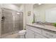 Well-lit bathroom with granite countertops, a glass enclosed shower, and modern fixtures at 7577 Oak Spring Ln, Davenport, FL 33837
