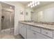 Bathroom featuring double sink vanity with granite counters and a glass enclosed walk-in shower at 7577 Oak Spring Ln, Davenport, FL 33837
