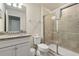 Bathroom featuring granite countertops, white cabinetry, and a glass-enclosed shower at 7577 Oak Spring Ln, Davenport, FL 33837