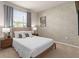 Cozy primary bedroom featuring a queen-size bed, neutral decor, and a large window for natural light at 7577 Oak Spring Ln, Davenport, FL 33837