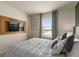 Cozy bedroom features a modern TV, sleek wooden fixture, and a gray color scheme at 7577 Oak Spring Ln, Davenport, FL 33837