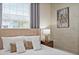 Comfortable bedroom with neutral tones, a decorative wall, and bright natural light at 7577 Oak Spring Ln, Davenport, FL 33837