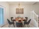 Dining room with a round table and seating for six, illuminated by a modern chandelier at 7577 Oak Spring Ln, Davenport, FL 33837