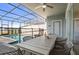 Outdoor patio with a dining table, seating, and view of the screened-in pool area with lake view at 7577 Oak Spring Ln, Davenport, FL 33837