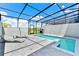 Inviting pool area with screened-in patio, featuring lounge seating and picturesque views at 7577 Oak Spring Ln, Davenport, FL 33837