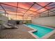 Enclosed pool with lounge chairs, a grill, and a beautiful sunset sky overhead at 7577 Oak Spring Ln, Davenport, FL 33837