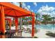 Resort-style pool with a covered lounge area, seating, and scenic landscaping with palms at 7577 Oak Spring Ln, Davenport, FL 33837
