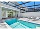 Screened-in pool area with patio seating and lounge chairs perfect for relaxing or entertaining at 7577 Oak Spring Ln, Davenport, FL 33837