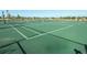 Well-maintained outdoor tennis court with a green surface and a net at 7577 Oak Spring Ln, Davenport, FL 33837