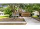 Single-Gathering home with a well-manicured lawn, beautiful trees, and a welcoming front door and a two-car garage at 805 Gordonia Ct, Deland, FL 32724