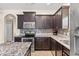Kitchen with stainless steel appliances, tile backsplash, and dark wood cabinets at 805 Gordonia Ct, Deland, FL 32724