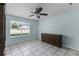Bedroom with tiled floors, a ceiling fan, a window, and a light blue wall at 8121 Via Bonita, Sanford, FL 32771