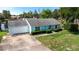 Charming single-story home with light blue exterior, well-manicured lawn, and attached garage at 8121 Via Bonita, Sanford, FL 32771