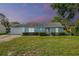 Charming light blue one-story home with a well-manicured front yard and lovely landscaping at 8121 Via Bonita, Sanford, FL 32771