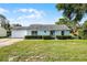 Charming light blue one-story home with a well-manicured front yard and lovely landscaping at 8121 Via Bonita, Sanford, FL 32771