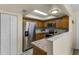 A lovely kitchen with wooden cabinets, a stainless steel refrigerator, and a tile countertop at 8121 Via Bonita, Sanford, FL 32771