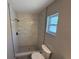 Bright bathroom features an updated shower with marble-look tile and a window providing natural light at 838 Haulover Dr, Altamonte Springs, FL 32714