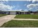 Charming single-story home with a well-manicured lawn, driveway, and a modern white and gray facade at 838 Haulover Dr, Altamonte Springs, FL 32714