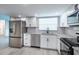 A modern kitchen featuring stainless steel appliances, granite countertops, and white cabinets at 838 Haulover Dr, Altamonte Springs, FL 32714