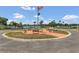 Community common area with benches, flagpole with American flag, palm trees, and scenic lake view at 106 Turtle Run, Umatilla, FL 32784