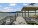 View of a wooden dock featuring a gazebo, bench seating, and a boat, overlooking a serene lake at 106 Turtle Run, Umatilla, FL 32784