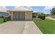 Home exterior featuring large driveway and metal roof at 106 Turtle Run, Umatilla, FL 32784