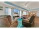 Cozy living room featuring plush seating, vibrant turquoise rug, ceiling fan, and large TV for entertainment and relaxation at 106 Turtle Run, Umatilla, FL 32784
