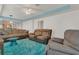 Spacious living room featuring comfortable seating, vibrant turquoise carpet, and an open layout ideal for entertaining guests at 106 Turtle Run, Umatilla, FL 32784