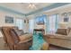 Inviting living room featuring a comfy seating area, a bright turquoise rug, and a large-screen TV for relaxing and entertaining at 106 Turtle Run, Umatilla, FL 32784