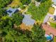 Aerial shot of a home with a gray roof, surrounded by green trees and well-maintained lawns at 1202 Marshall Ct, Eustis, FL 32726