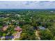 Aerial view of a home within a defined property boundary, surrounded by trees and neighboring houses at 1202 Marshall Ct, Eustis, FL 32726