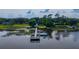 Aerial view featuring a long wooden dock, a boat, and a gazebo extending into a tranquil lake at 1202 Marshall Ct, Eustis, FL 32726