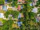 Overhead view of a property within defined boundaries, nestled among lush greenery and neighboring homes, including one with a pool at 1202 Marshall Ct, Eustis, FL 32726