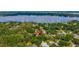 Aerial view by a lake shows house in green neighborhood marked with location pin for serene lakeside living at 1202 Marshall Ct, Eustis, FL 32726