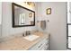Elegant bathroom featuring a marble countertop, white cabinets, and vintage-inspired lighting at 1202 Marshall Ct, Eustis, FL 32726