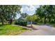 Charming home exterior with a well-kept lawn, mature trees, and a paved walkway at 1202 Marshall Ct, Eustis, FL 32726