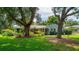 Lovely home with mature landscaping, beautiful lawn, and welcoming entryway, all framed by majestic trees at 1202 Marshall Ct, Eustis, FL 32726