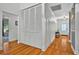 Bright hallway featuring hardwood floors, a coat closet, and paneled wainscoting, leading to the front door at 1202 Marshall Ct, Eustis, FL 32726
