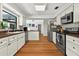 Well-lit kitchen with white cabinets, stainless steel appliances and wood countertop at 1202 Marshall Ct, Eustis, FL 32726