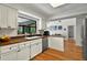 A well-lit kitchen features wood floors, white cabinets, stainless steel appliances, and butcher block countertops at 1202 Marshall Ct, Eustis, FL 32726