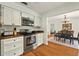 Kitchen features stainless steel appliances, white cabinets, and hardwood flooring, adjoining the dining room at 1202 Marshall Ct, Eustis, FL 32726